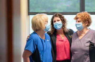 Tina Livaudais stands with two DaVita nurses as they smile at each other. 
