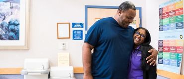 A former DaVita patient who has received a transplant embraces a member of his DaVita care team